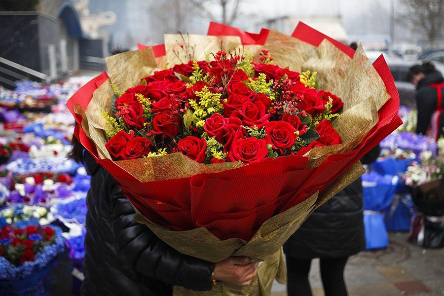 A woman holds a bouquet of Valentines Day roses at the flower market in Beijing, Tuesday, Feb. 14, 2017. Valentines Day is not a tradition in China but is becoming increasingly popular as Chinese adopt Western customs, encouraged by retailers who see them as a way of boosting sales. (AP Photo/Andy Wong)