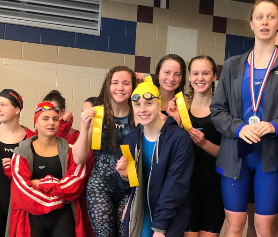 The girls 200 Medley relay stands on the podium after placing 4th. Zoe Uehlinger, Taryn Kooyers, Annie LeBlanc and Avery Fuhr holding up their ribbons.