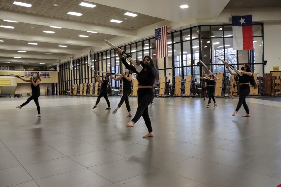 Practicing the varsity rifles warm up exercises, Winter Guard captain Danielle Fontenot concentrates on technique and skill set. The guard will present their performance titled The Introduction of Color at the first contest of the season.
