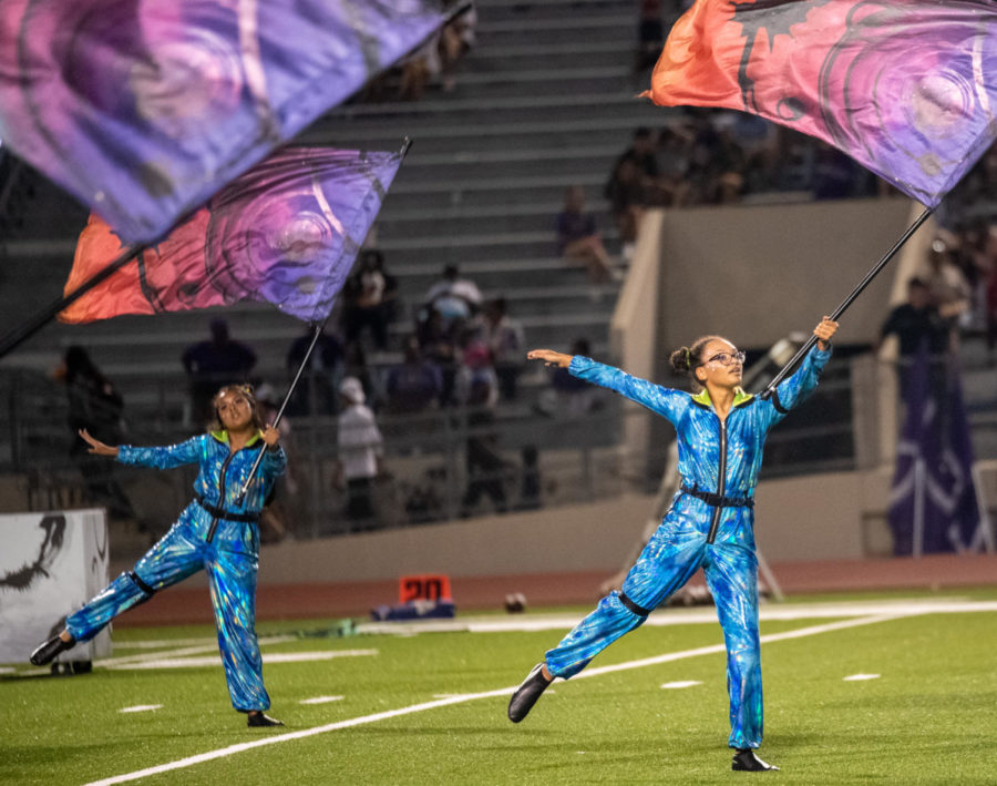 Completing the ending flag feature of Are You Out There?, color guard members senior Abigail Lopez and junior Angela Lopez concentrate on timing, precision and grace.