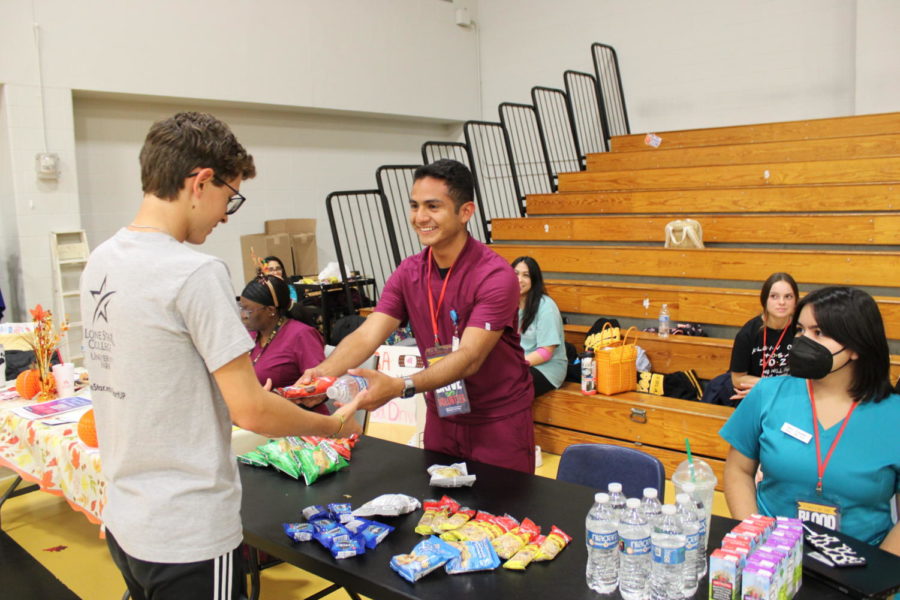 Blood drive volunteers hand out snacks to blood donors in the small gym. Blood donors 16-years-old and over with a parent permission slip are able to donate blood at the school. 