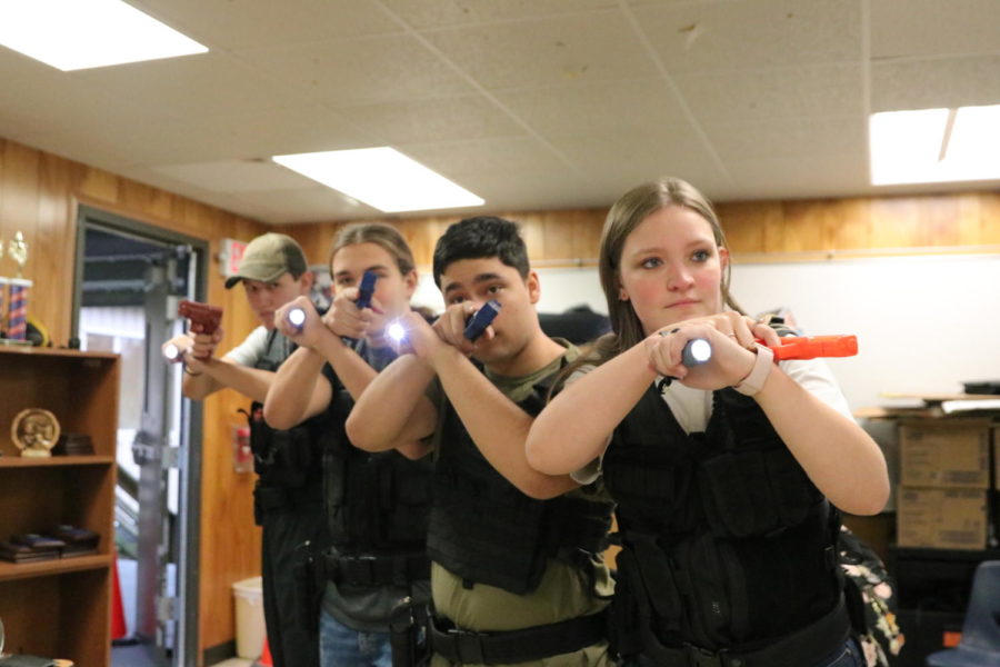 Sophomore Tommy Jones, senior Braedon Flory, sophomore Jackson Blankenship, and senior Sara Baskett
from the Law Enforcement SWAT Practice gear up with bulletproof vests, holster belts, imitation guns, and flashlights to prepare for their future jobs in policing.