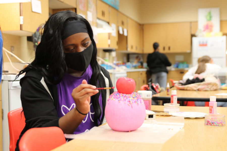 Senior Zoriah Christie paints her pumpkin for the design competition. Every year students in Interior Design decorate pumpkins for a Halloween design contest in order to delve into color schemes, product texture, and application of creative vision.
