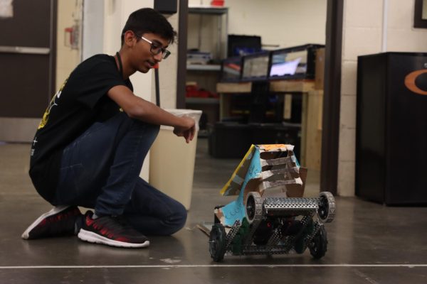 Learning to use gear ratio, speed and torque during the 5th period Tractor Pull project, Hamza Syed controls a robot tractor with enough torque to pull the weighted trailer across the line within seven seconds.