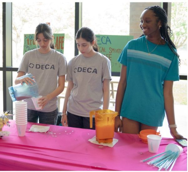 Making smoothies, Zia Hooda, Zofia Hooda and Alana Trotman represent DECA at their group's carnival booth. DECA club sold smoothies from Tropical Cafe, and gave out buy one, get one coupons. Their flavor options were Strawberry or Mango Pineapple.
