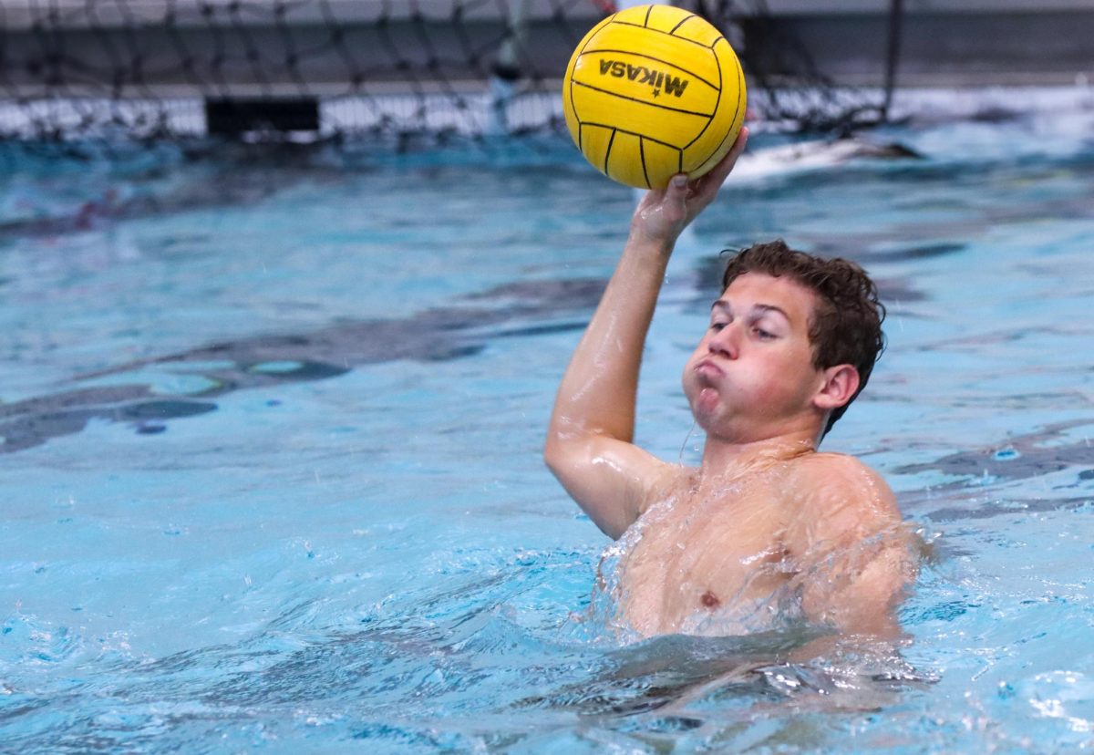 Prior to the first match, junior Hunter Haberman practices dry passes with teammates. The varsity girls and boys teams played Tomball High School Aug. 29. Although both new teams lost their first ever matches, they were able to score points against a water polo team that has been established since the 1990s.