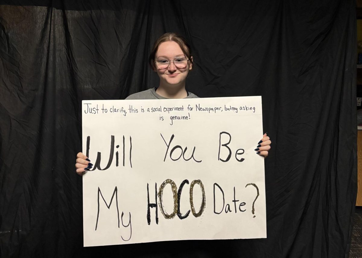 With poster in hand, junior Bella Meyers tries a homecoming experiment: will someone say 'yes' to a friend?