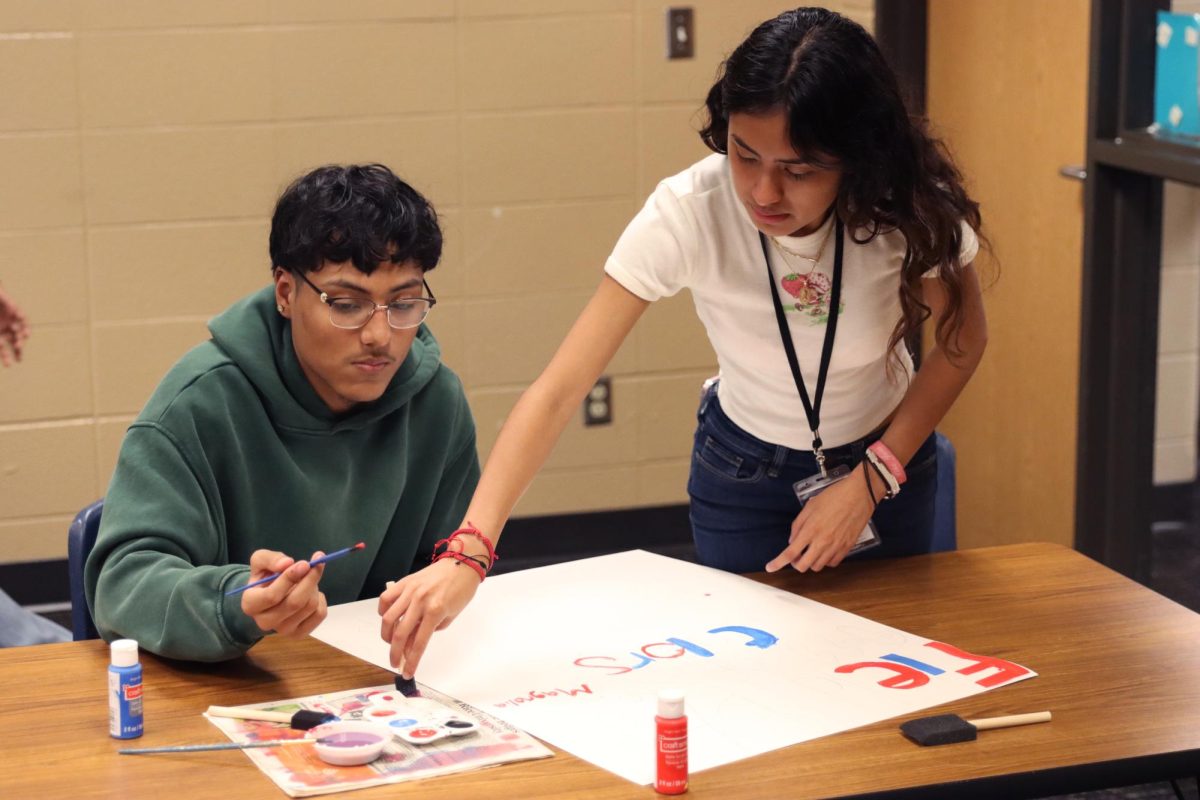 Working together to paint signs, senior Aiden Pereira and senior Darexy Salas help spread the word for the dress up days, to show school spirit and get the student body excited to participate
